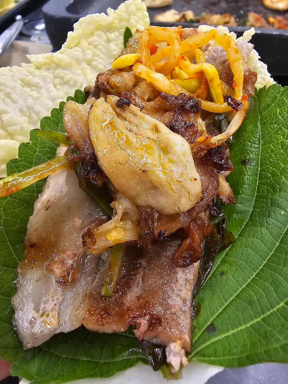 Picking up a piece of grilled thin-cut pork belly
