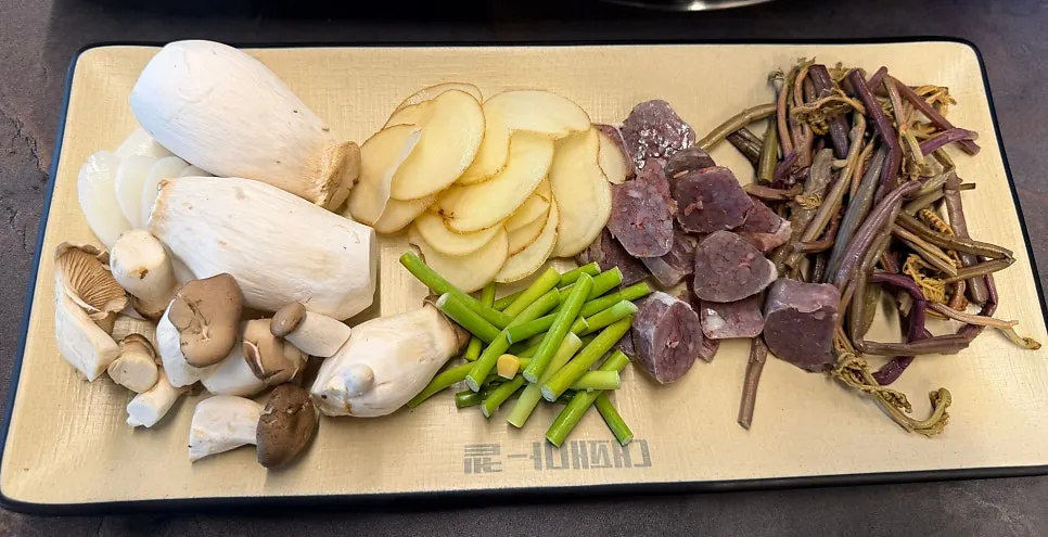 Mushrooms, potatoes, garlic stems and sundae grilling together on the pan
