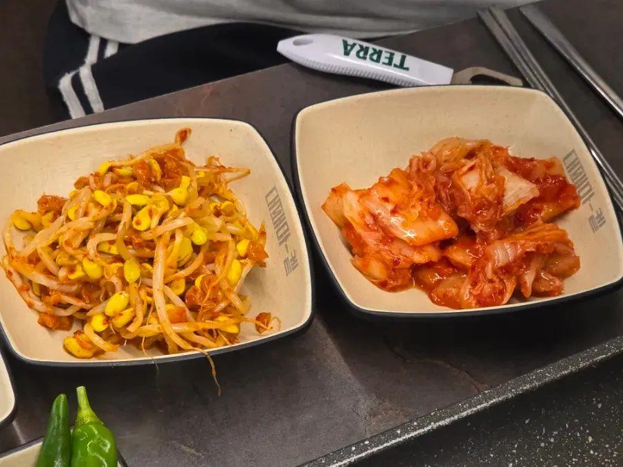 Bean sprouts and napa cabbage kimchi brought over on a plate