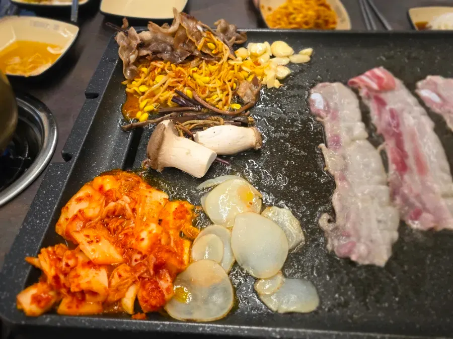 Vegetables and side dishes grilled together with the pork belly
