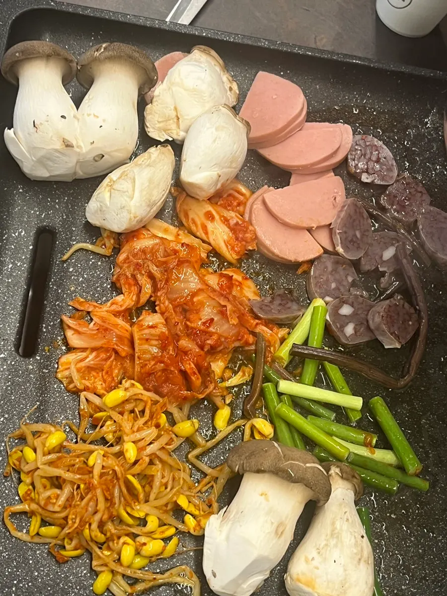 Grill full of side dishes and meat