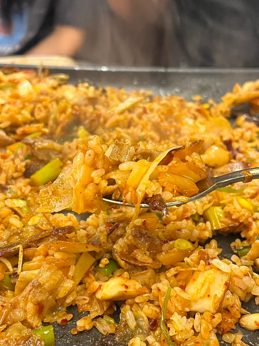 Two bowls of fried rice being cooked on the grill