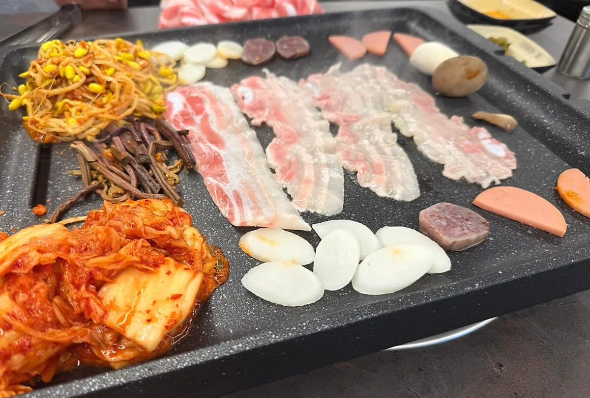Table spread of thin-cut pork belly at Daepae Maket Busan Daeyeon Branch