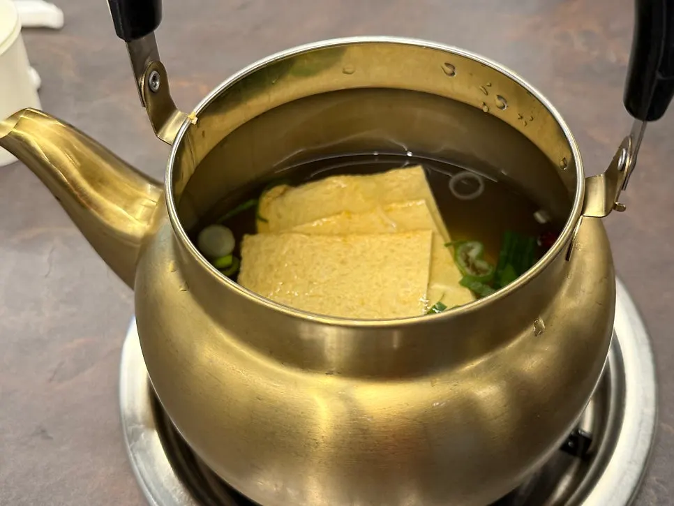 Complimentary odeng soup served in a kettle