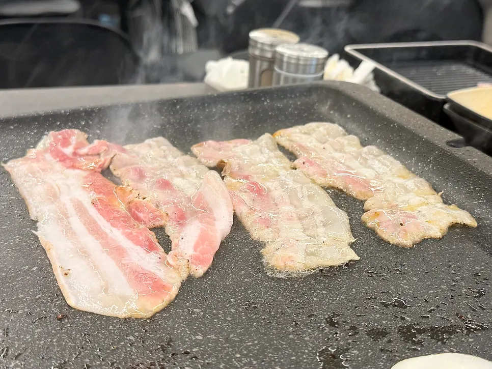 Ssol-o-gyeopsal pork belly cooking on the grill