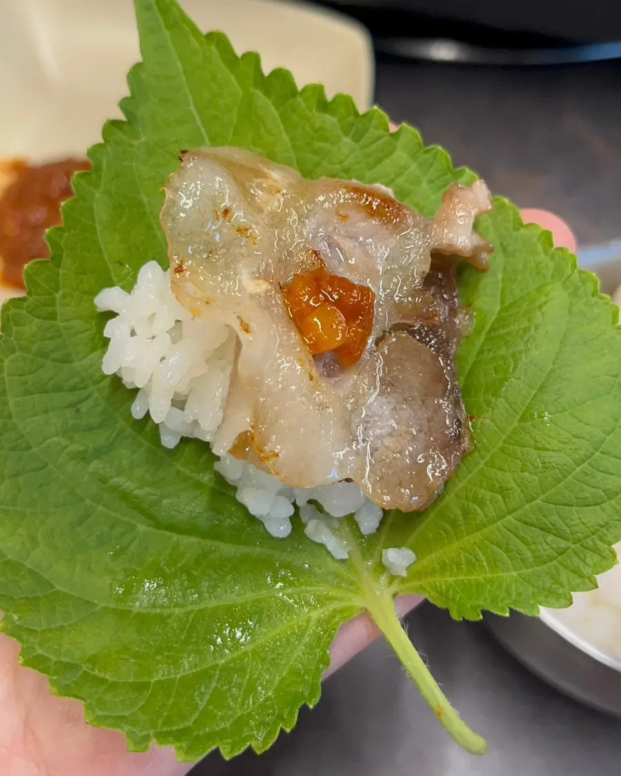 A piece of daepae pork belly placed on rice
