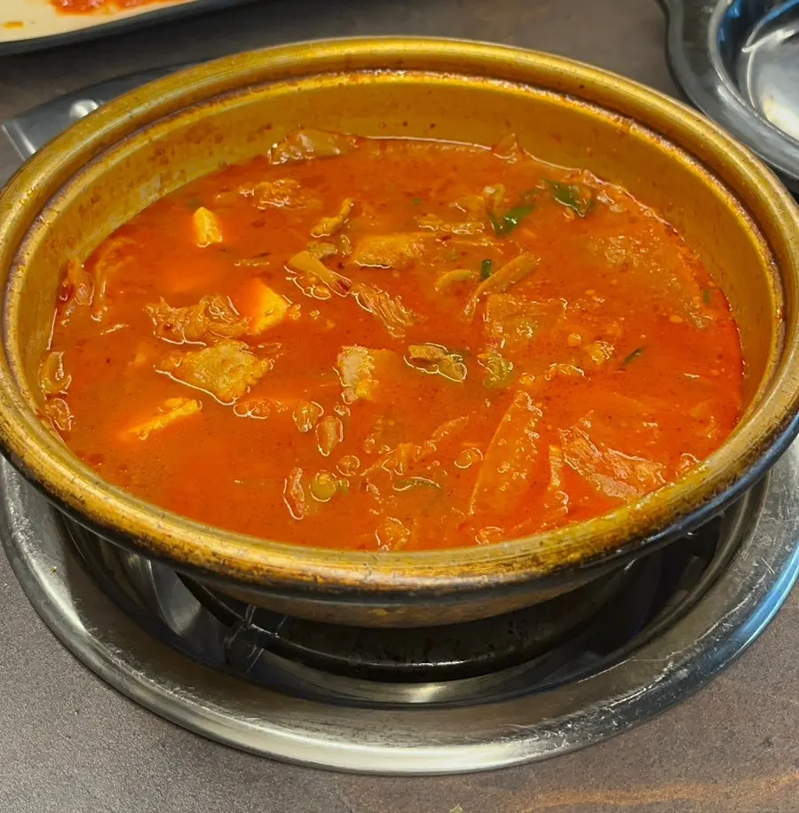 Kimchi stew being reheated on the burner