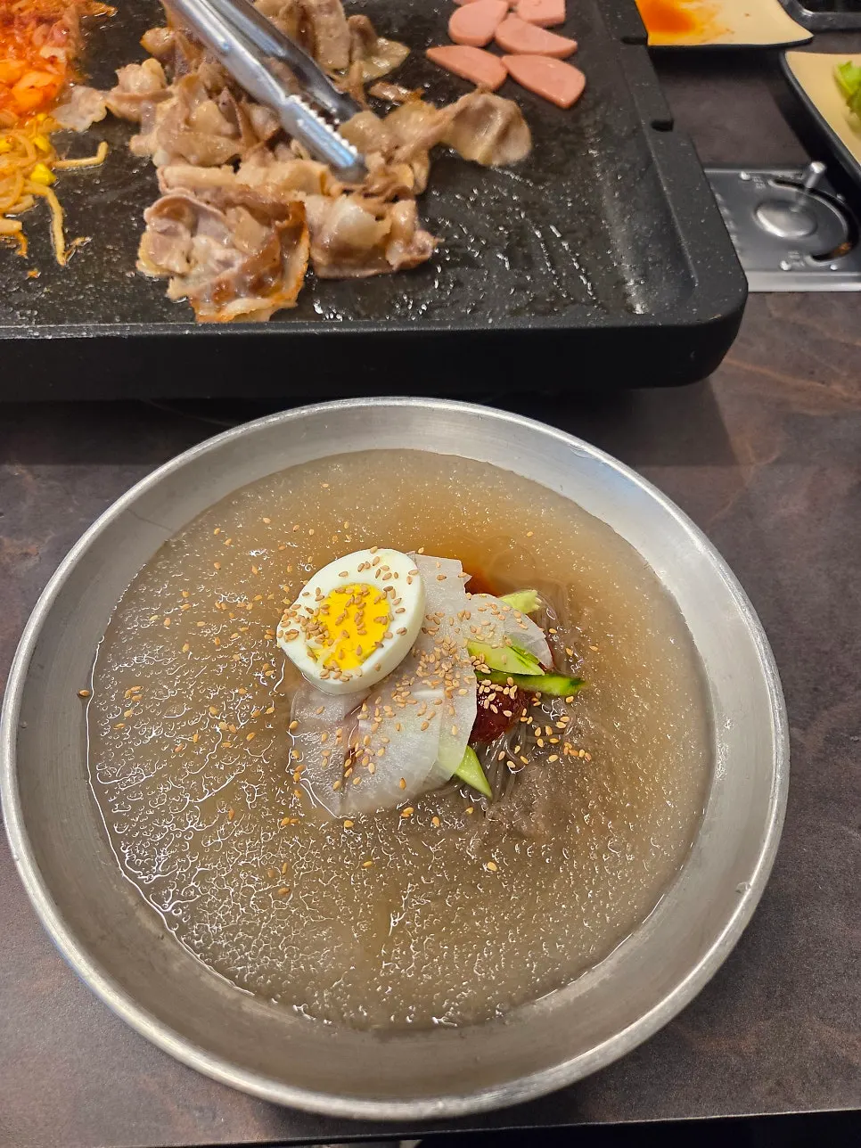 A bowl of water naengmyeon topped with dadegi