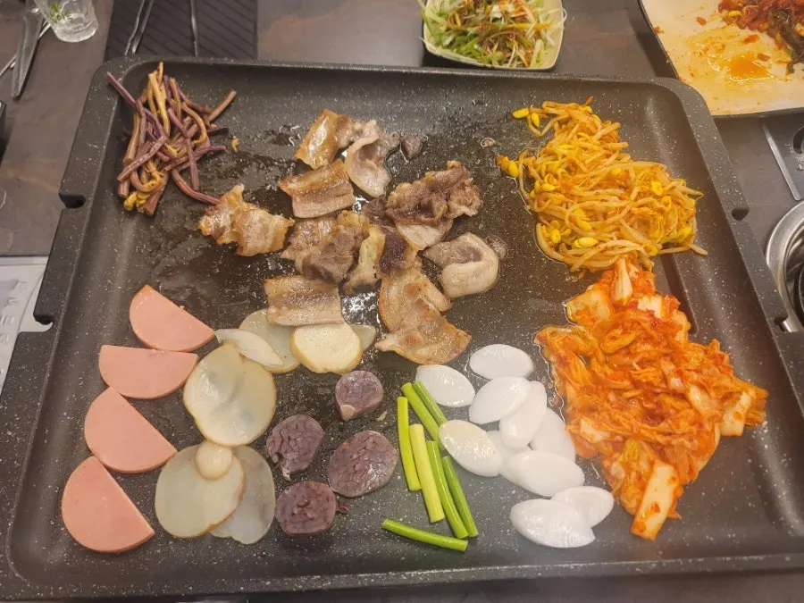 Sausage, rice cake, and kimchi grilled together on the large pan