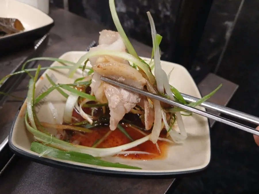 Sliced pork belly with shredded green onion and sauce