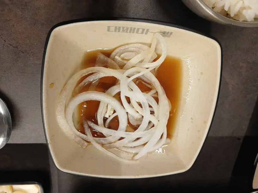 Sliced pork belly eaten with pickled radish wrap