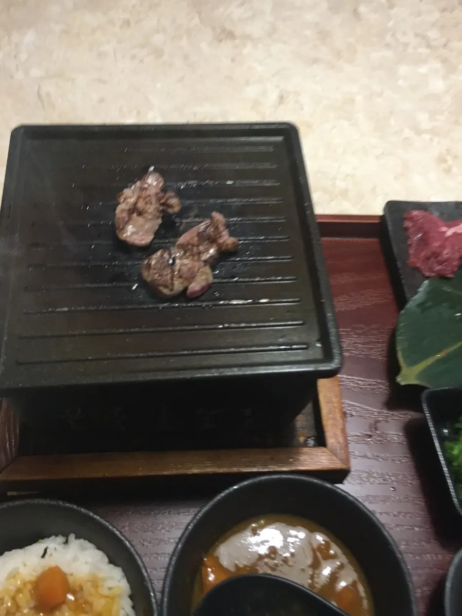 불판 위에 올린 야키니쿠 고기 두 점