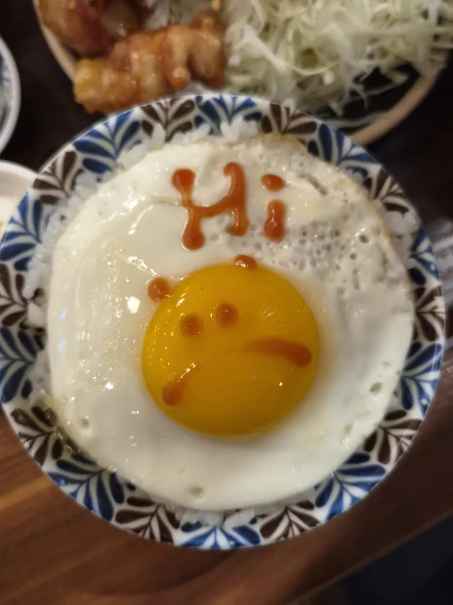 Hi가 적힌 반숙 계란과 깐풍기 정식