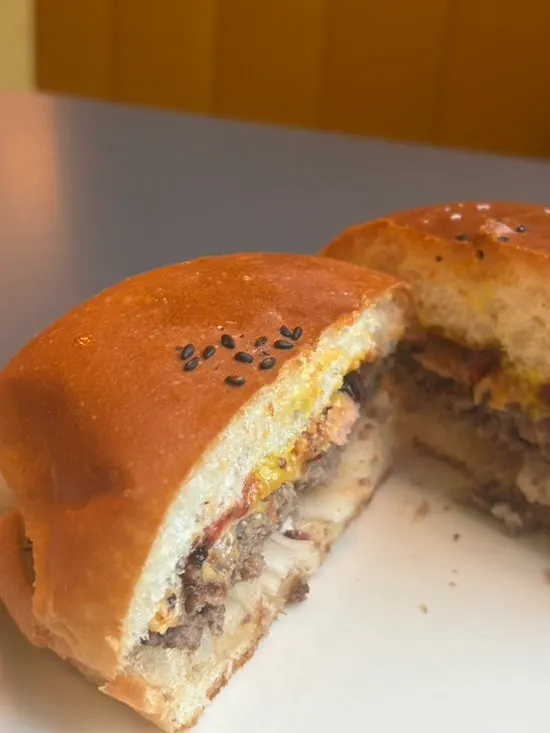 Close-up of the bacon cheese burger held in hand