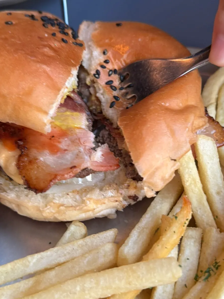 Holding the bacon cheeseburger in hand