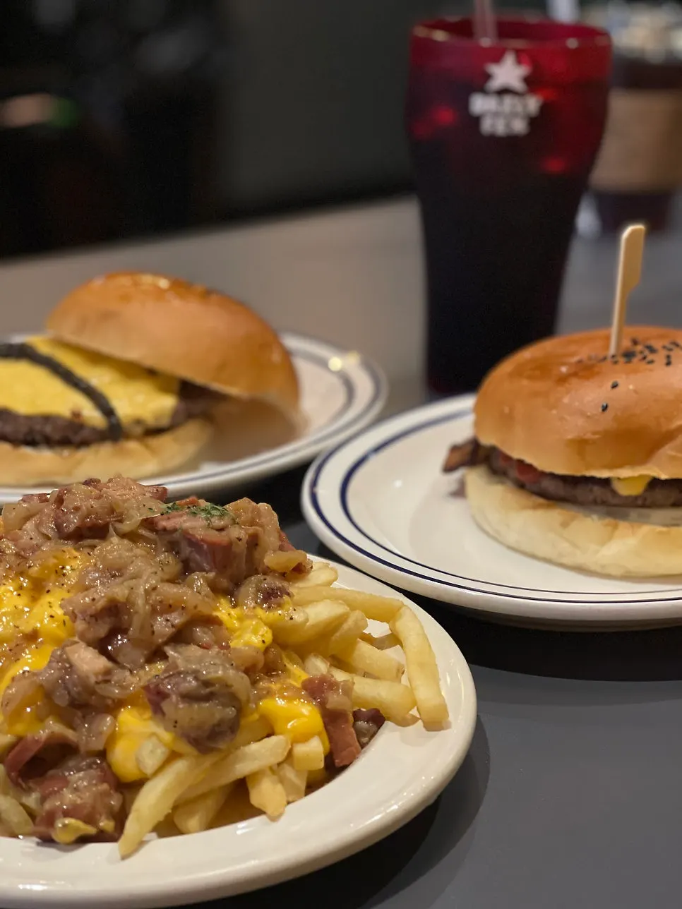 Table spread with two burgers and bacon cheese fries