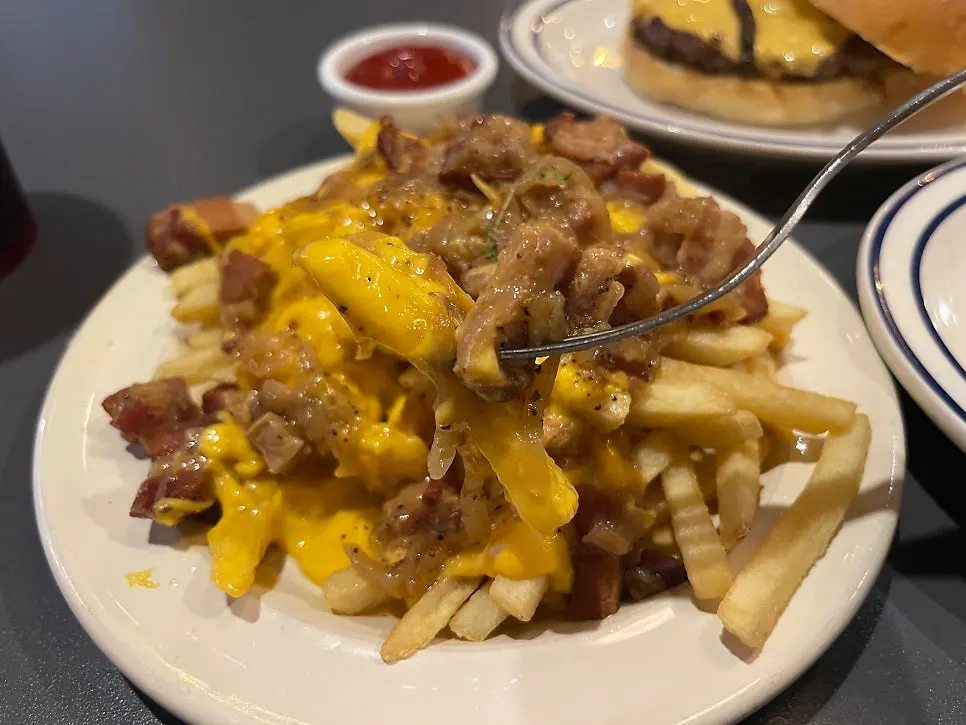 Fries topped with chunky bacon and caramelized onions