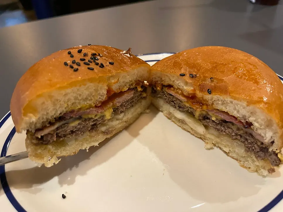 Bacon cheese burger cut in half showing the inside