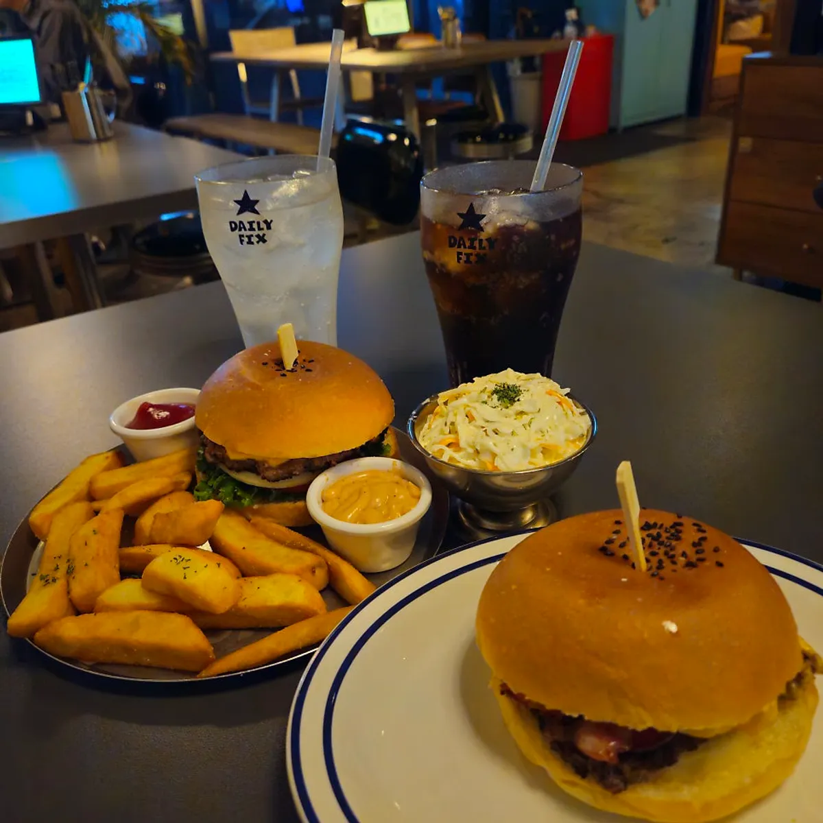 Classic Burger set, Bacon Cheeseburger, and coleslaw laid out together