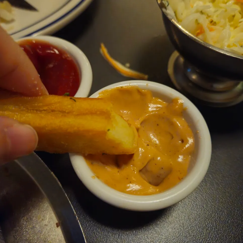 Fries dipped into the signature dipping sauce