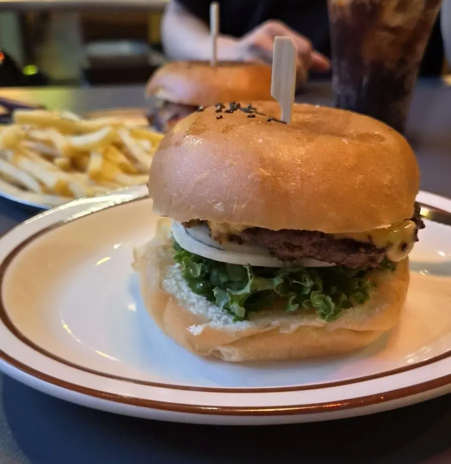 Classic Burger with lettuce peeking out of a sesame bun
