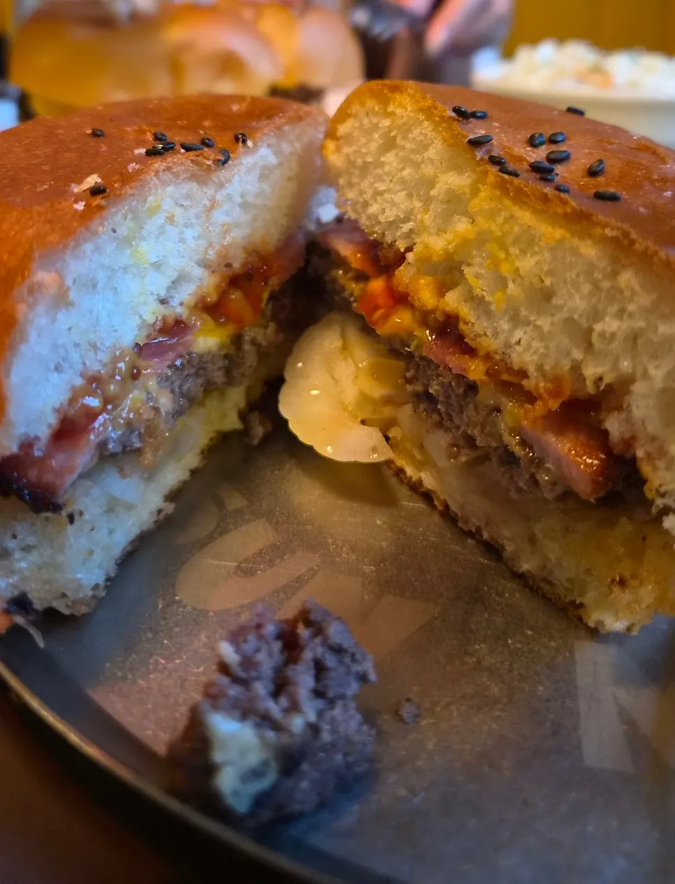 Cross-section showing layers of bacon, cheese, and patty