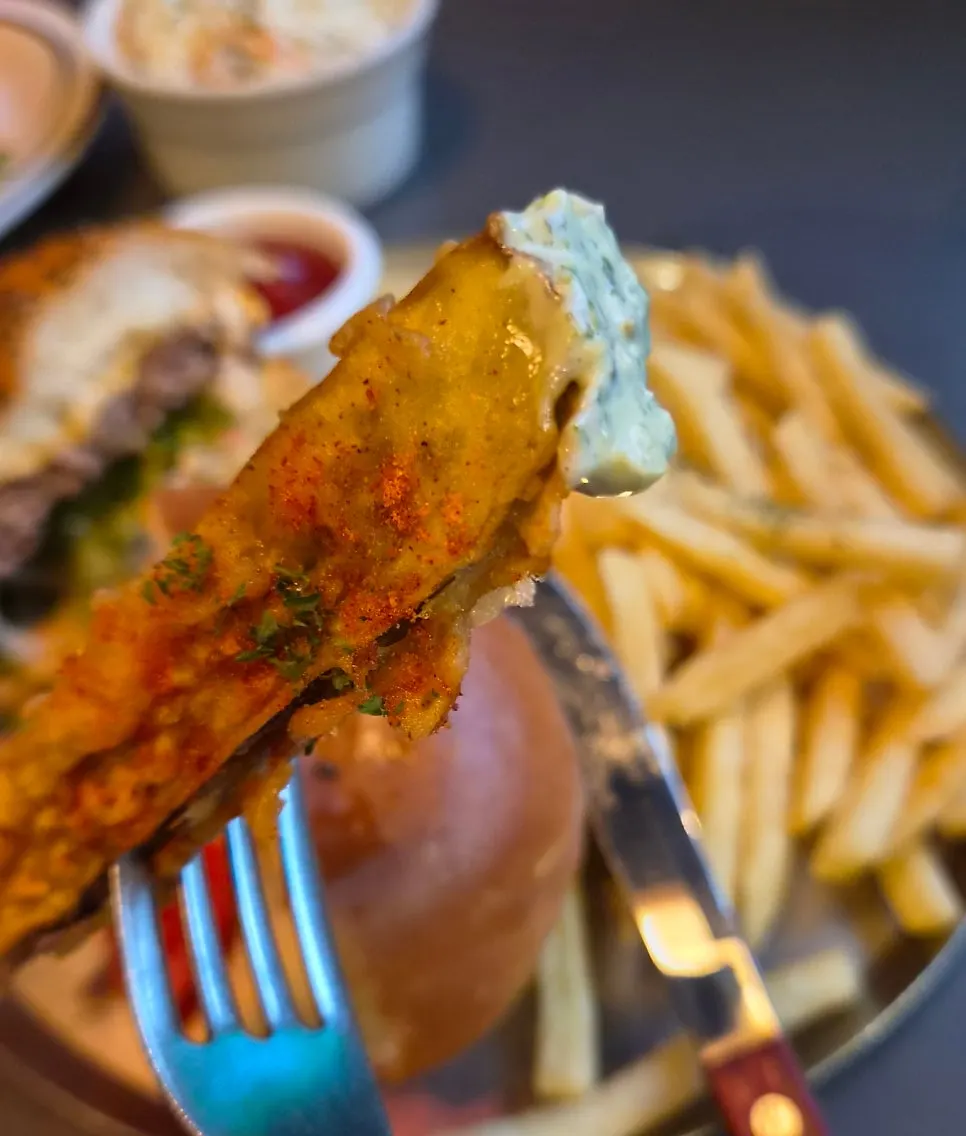 Eggplant fries being dipped into sauce