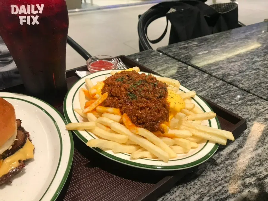 Chili cheese fries topped generously with chili sauce
