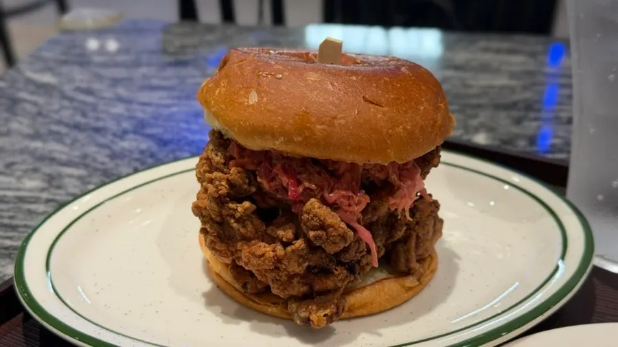 Crispy chicken burger with a skewer stuck through it