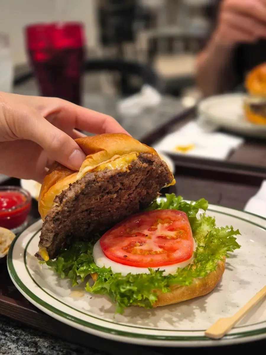Cross-section of a classic burger with hanwoo patty, tomato, and lettuce