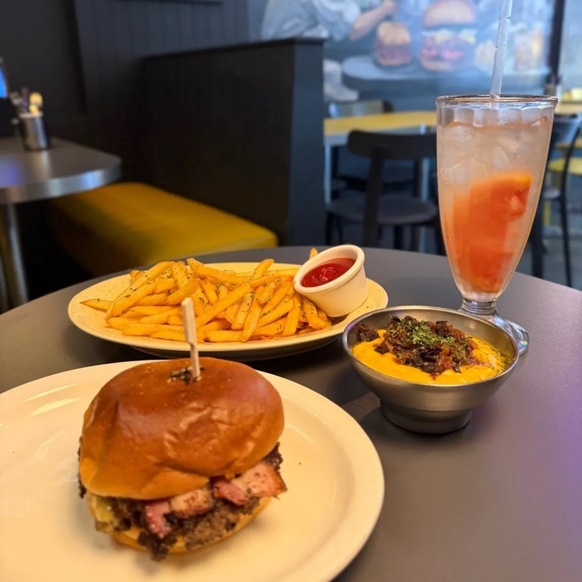 Full spread of bacon cheeseburger, bacon cheese fries, and grapefruit ade