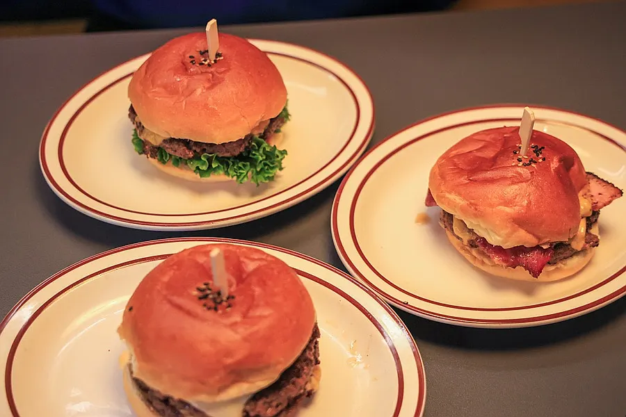 Three burgers served together on ceramic plates