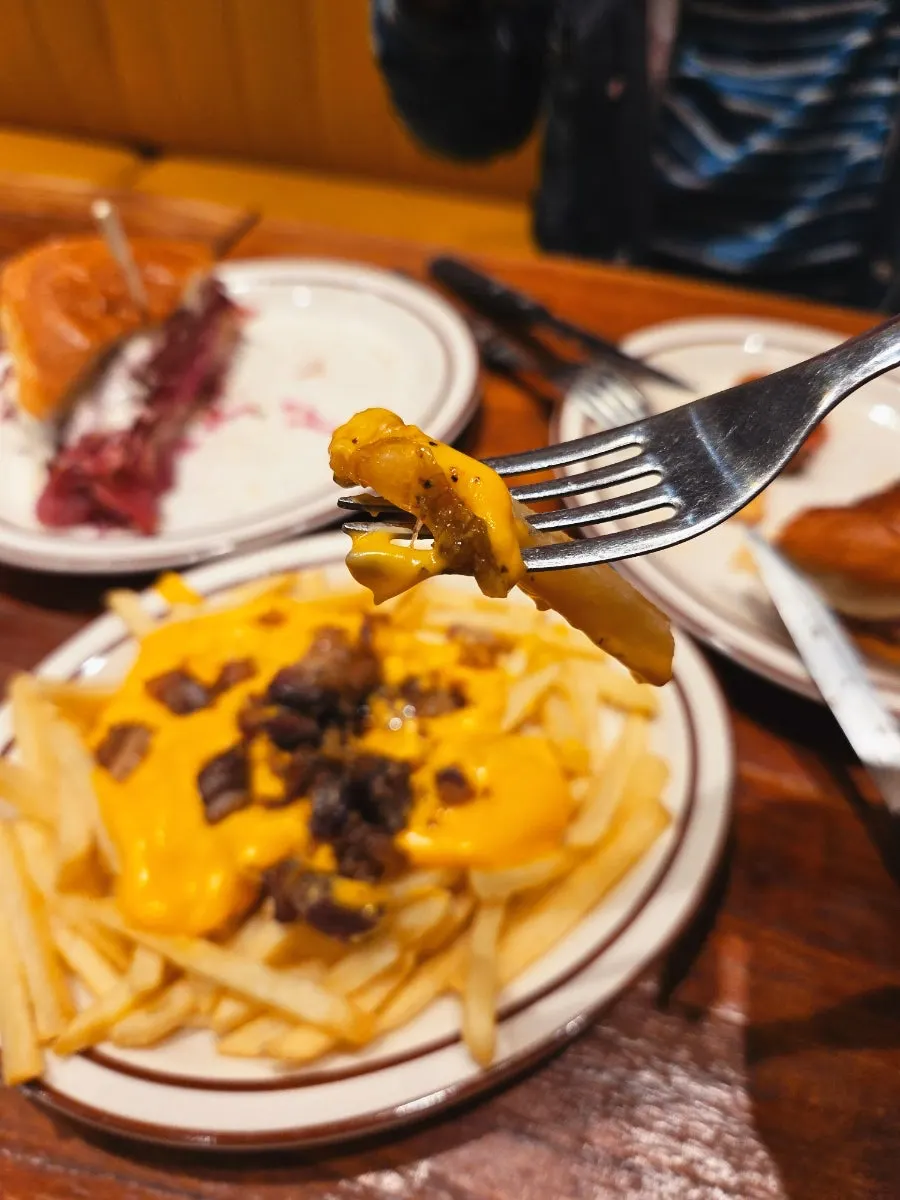 Close-up of cheese fries topped with bits of bacon