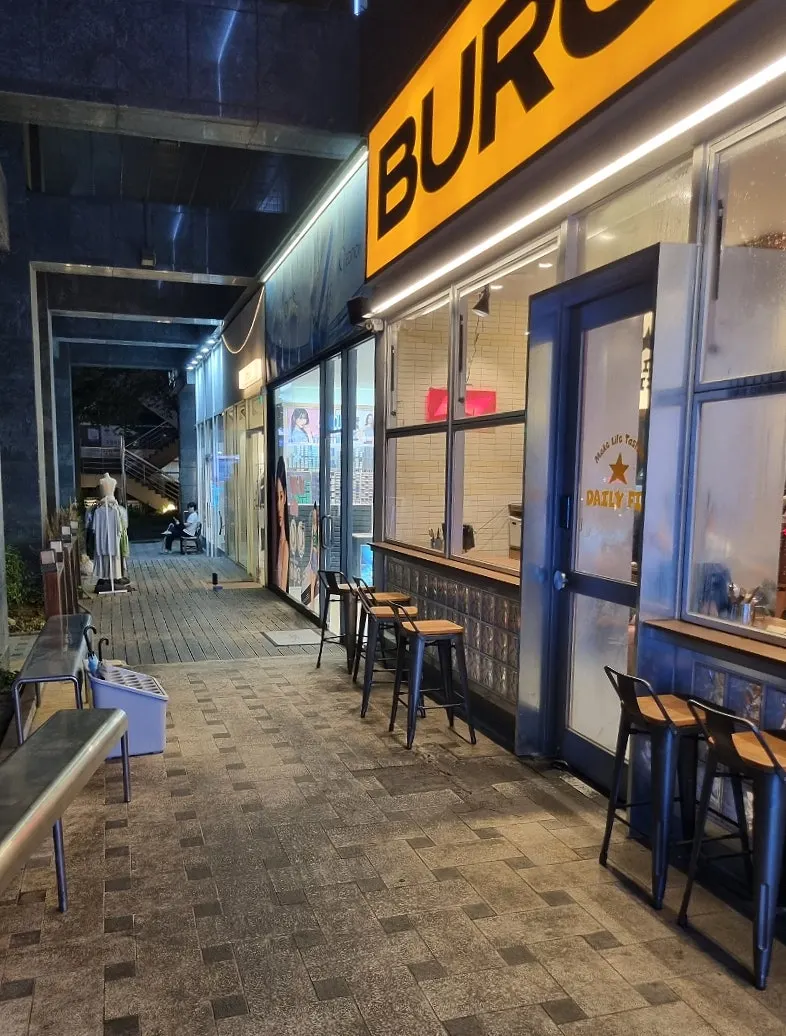 Store entrance with a bright yellow BURGER sign