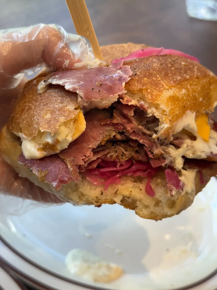Pastrami ciabatta sandwich stacked with layers of beef brisket