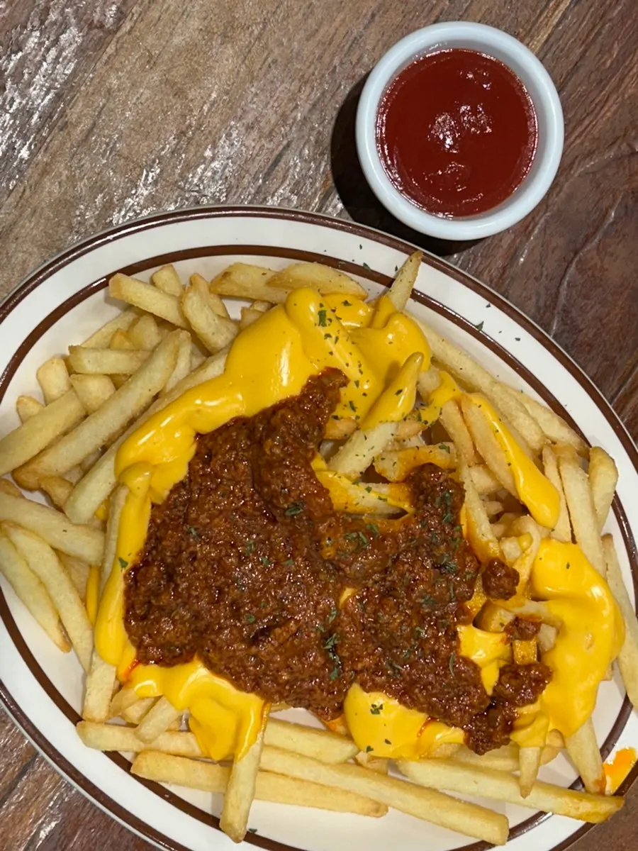 Chili cheese fries topped with cheese and chili sauce