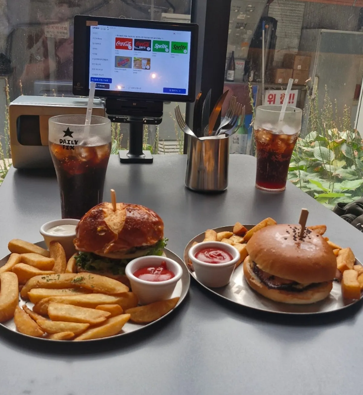 Table spread with bacon cheeseburger and pretzel bun classic burger