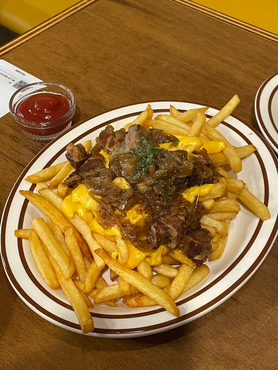 Close-up of bacon cheese fries with meat visible under the cheese
