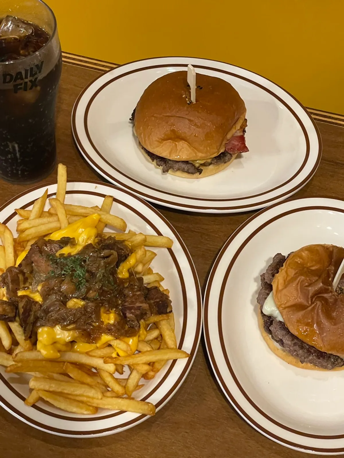 Full spread of two burgers and bacon cheese fries