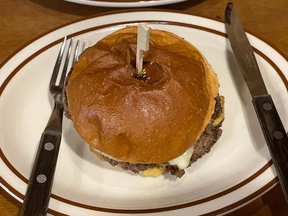 Double cheese burger lifted up by hand