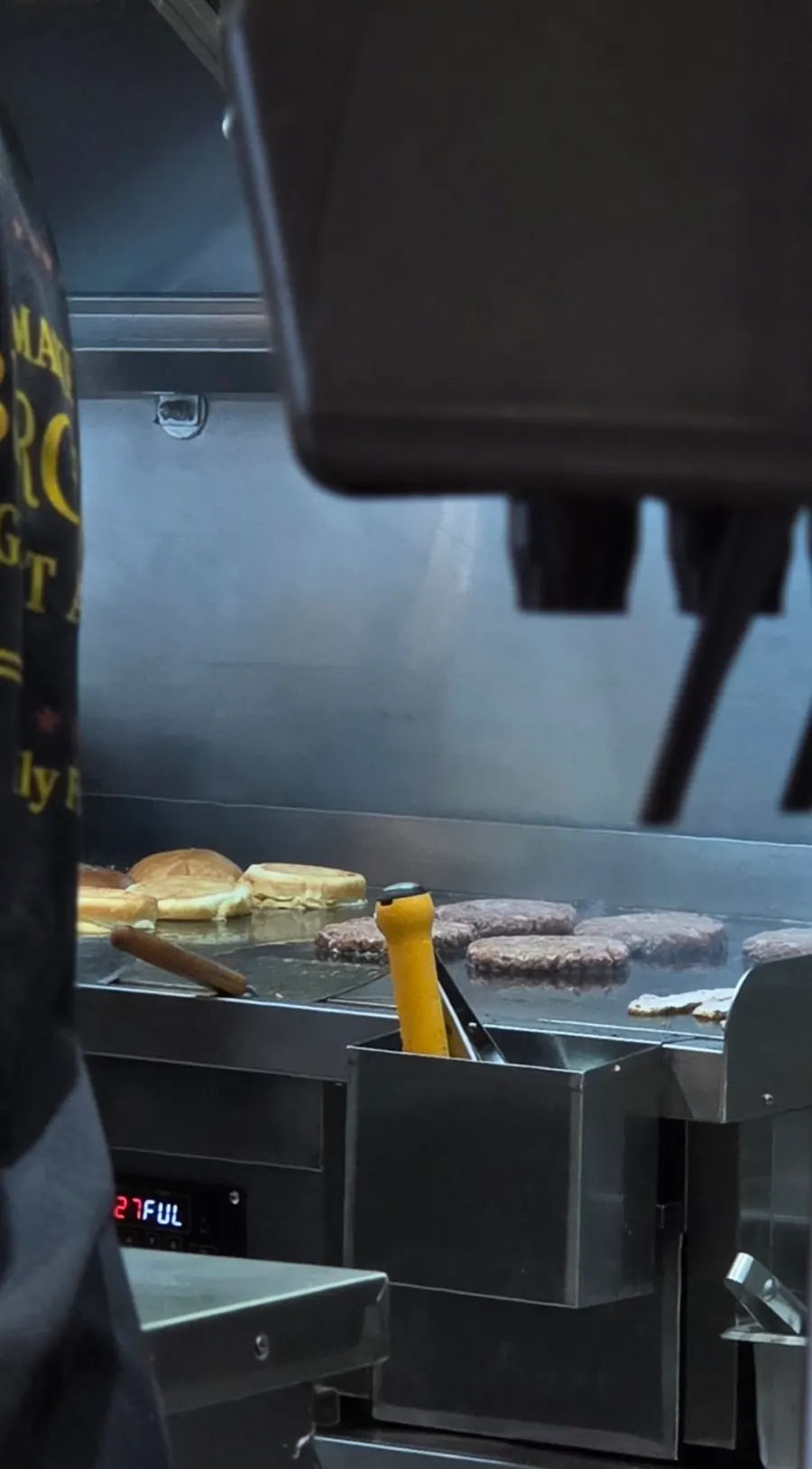 Open kitchen where patties and buns are grilled