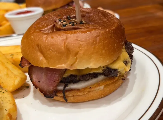 Cross-section of the burger showing Korean beef patty, bacon, and cheese layered together