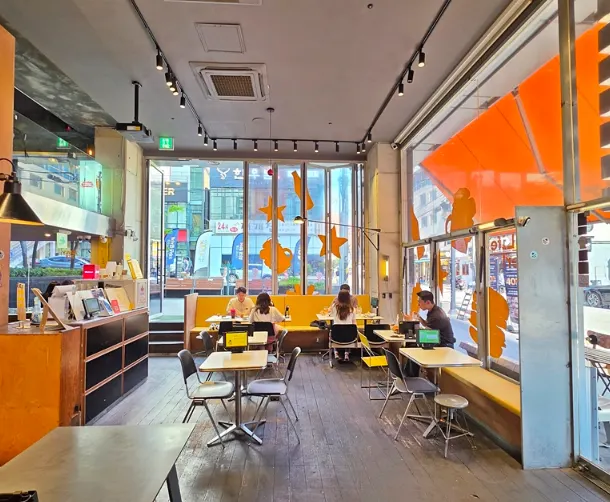 Interior space with sunlight streaming through floor-to-ceiling windows