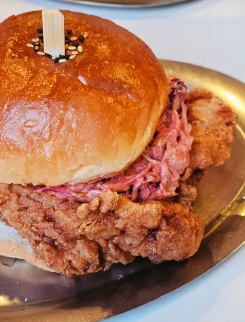 A chicken burger roughly the size of a face