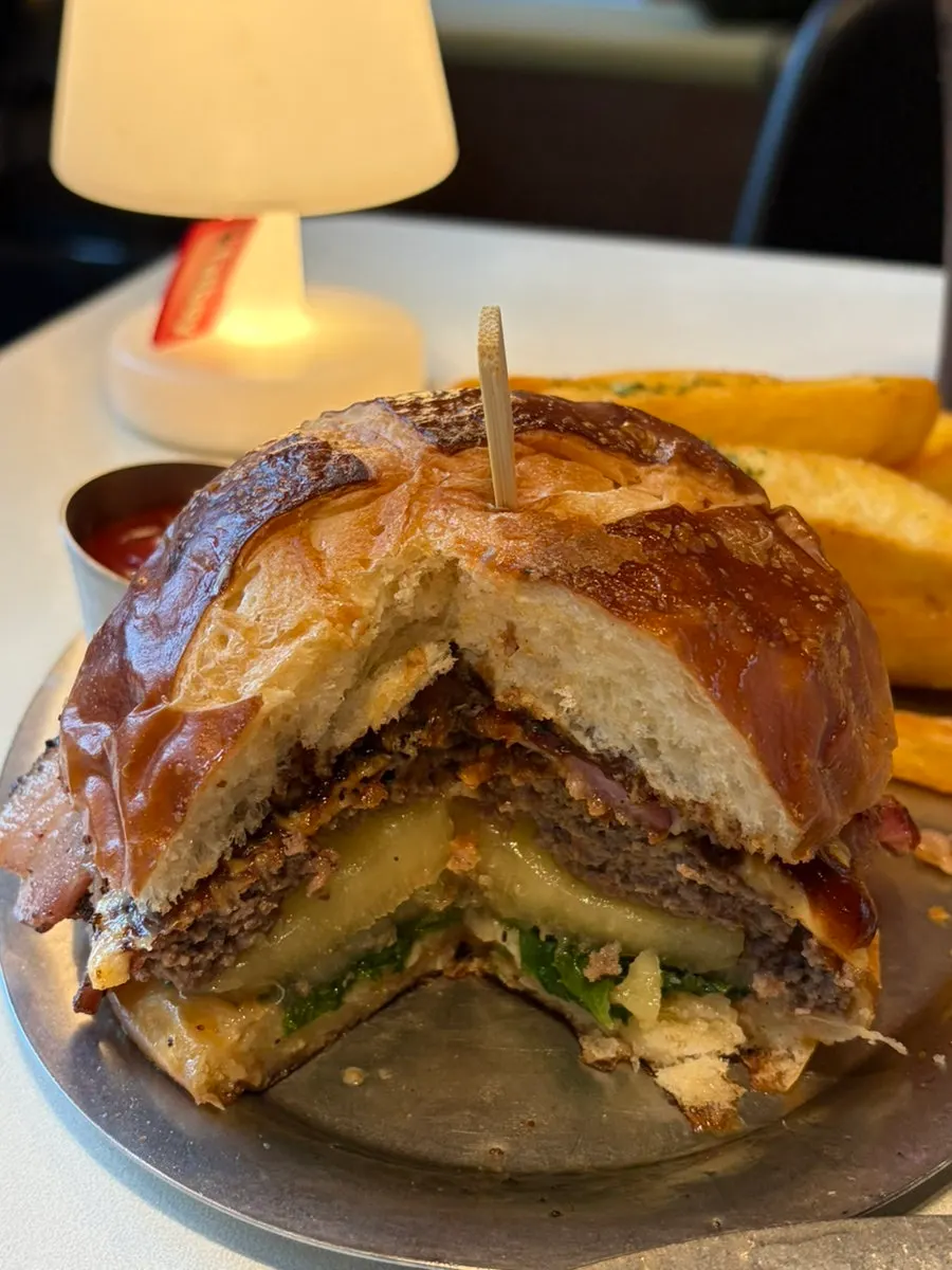 A bite taken out of the Hawaiian Bacon BBQ Burger