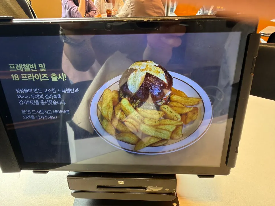 Sign for new pretzel bun and 18 fries menu items