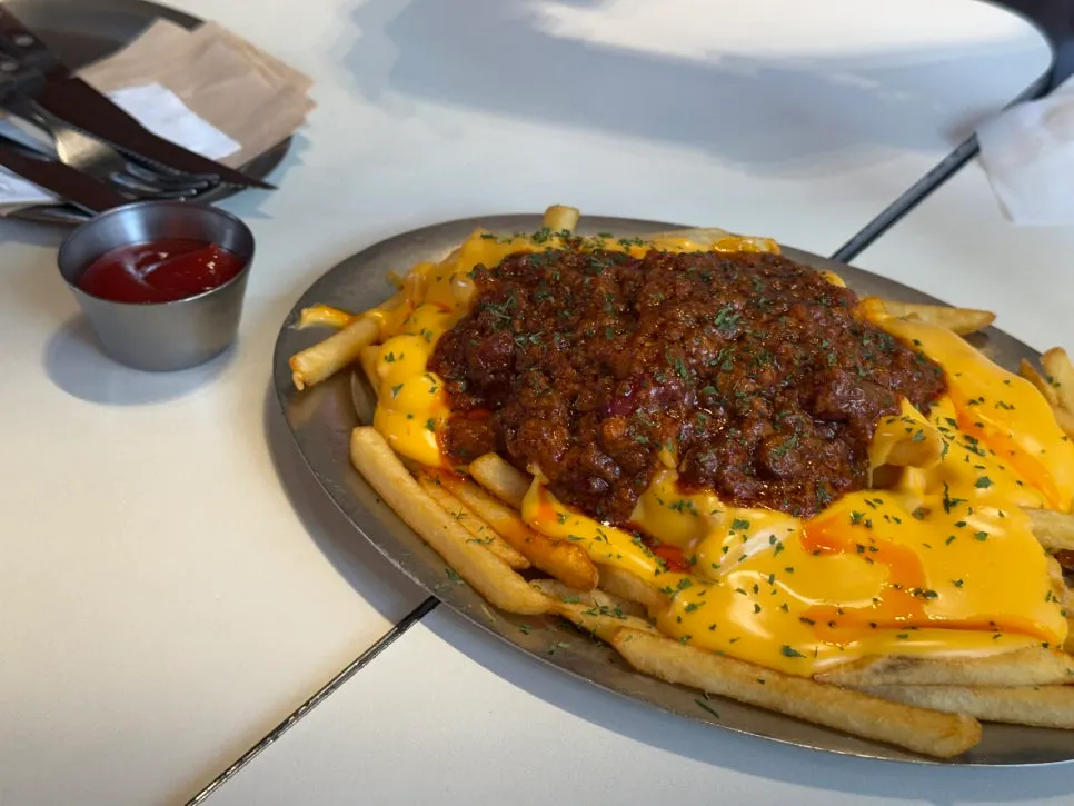 Large portion of chili cheese fries with ketchup on the side