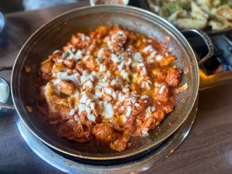 Cheese dakgalbi piled onto a piece of potato pancake
