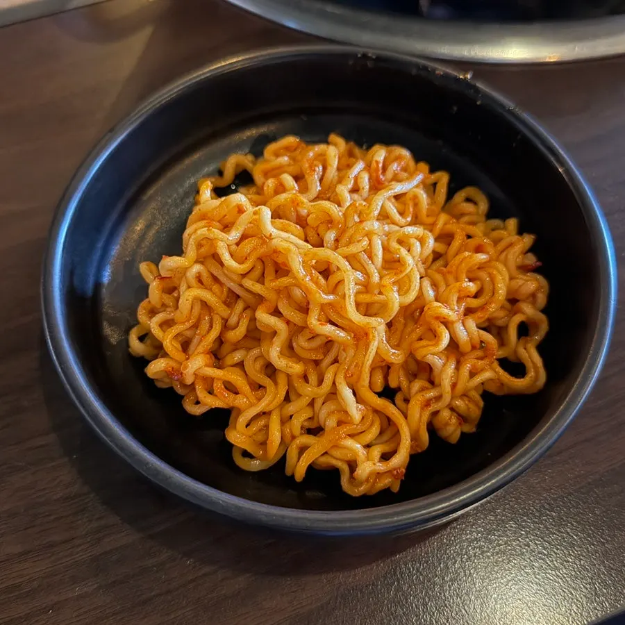 A pan of cheese dakgalbi topped with melted cheese