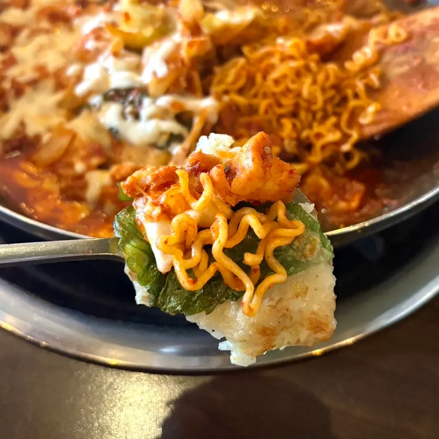 A wrap of potato pancake dipped in sauce